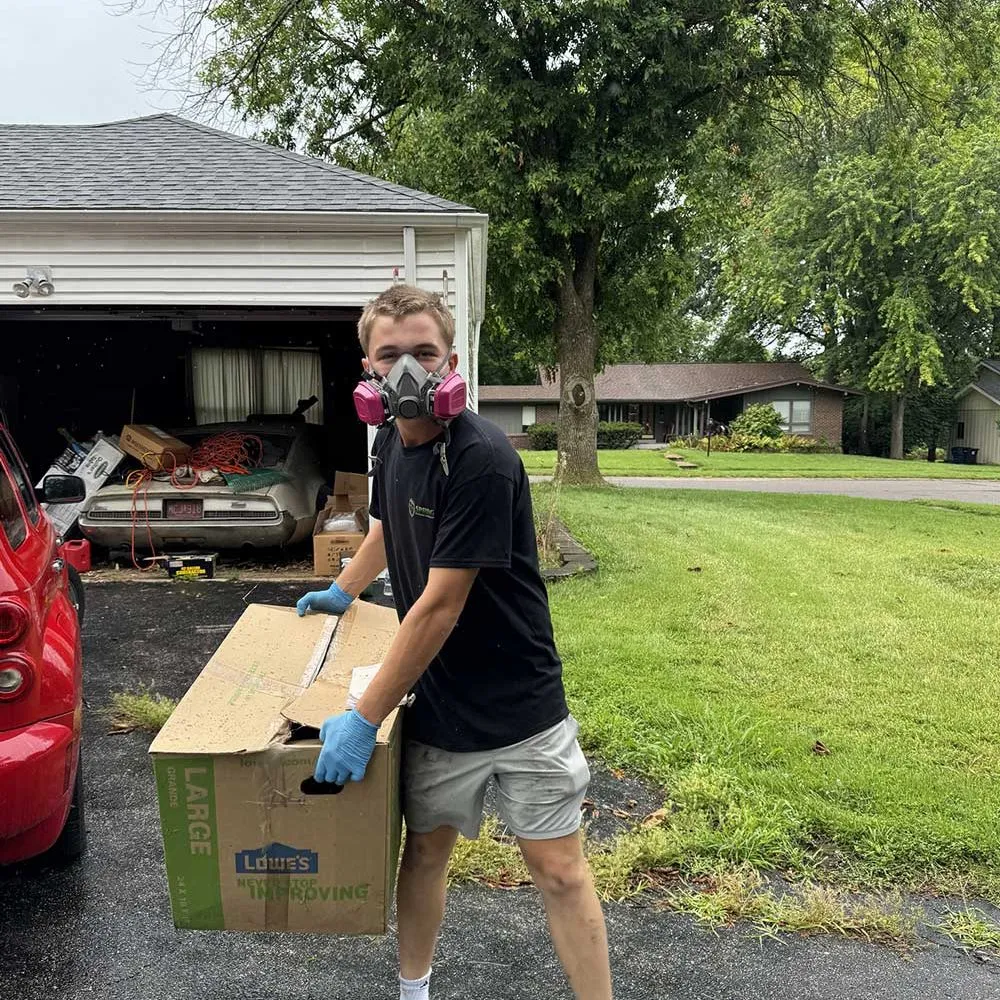 Spring Cleaning Company team member with protective equipment handling items for eco-friendly recycling and disposal in St. Louis, Missouri