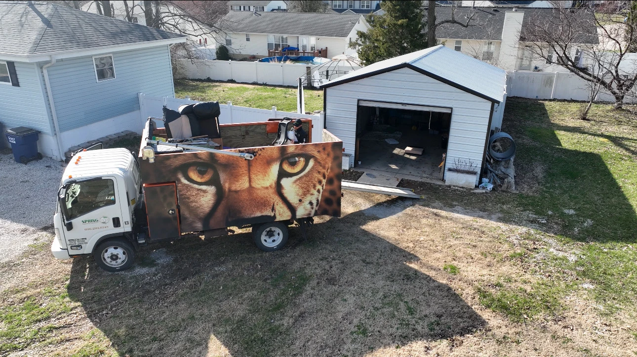 Spring Cleaning Company junk removal truck outside disconnected garage getting loaded up in St. Louis, Missouri