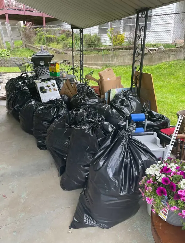 Line of trash bags and junk outside on patio ready for Spring Cleaning Company pickup in St. Louis, Missouri
