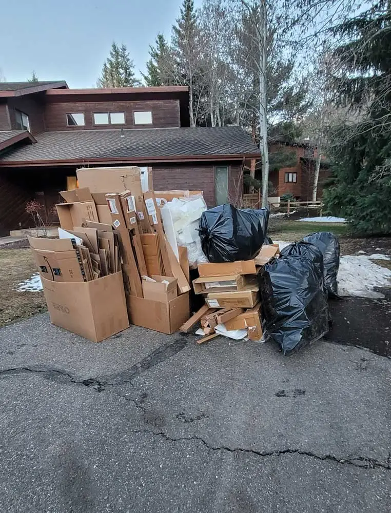 Boxes and bags on curb outside residential home ready for JunkItNow.com pickup in St. Louis, Missouri