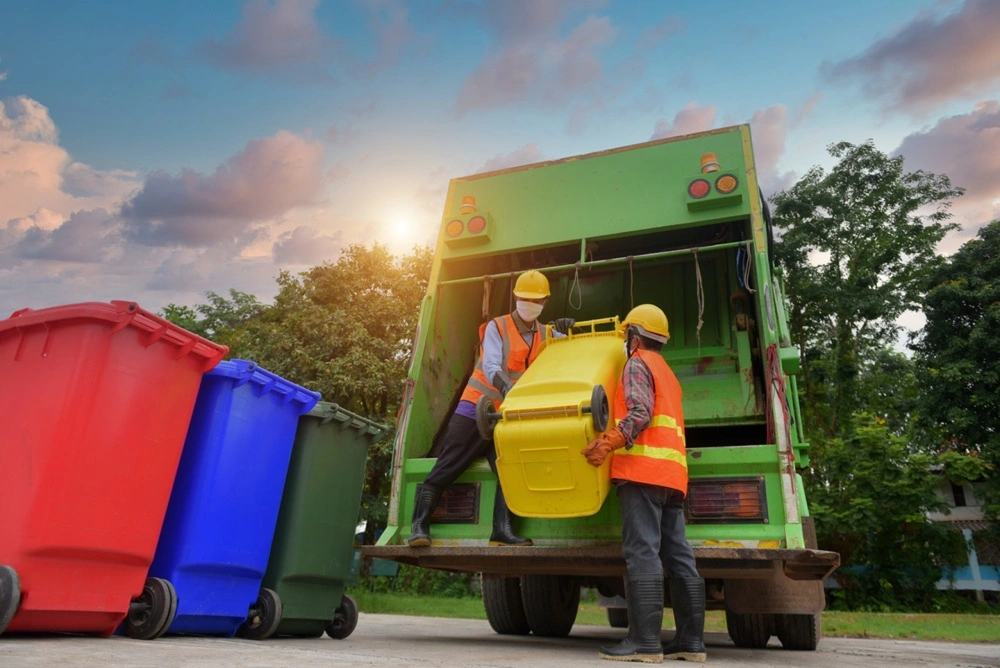 Spring Cleaning Company crew loading a waste bin into a junk removal truck in Sunset Hills, Missouri