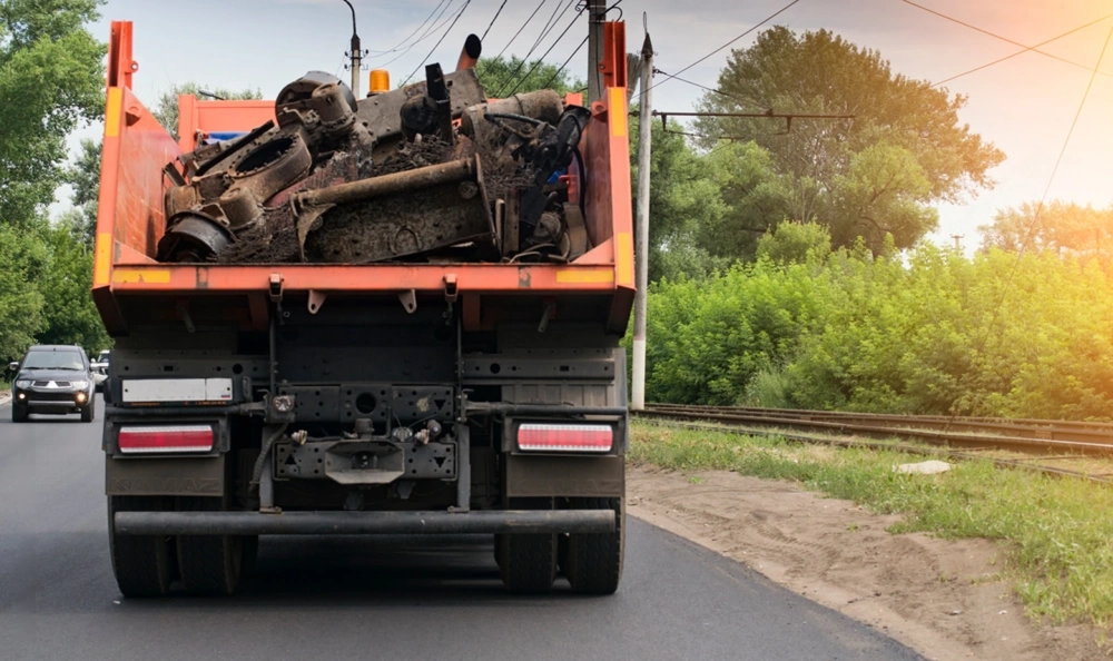 Junk removal truck hauling a load of scrap metal and debris out of Earth City, Missouri