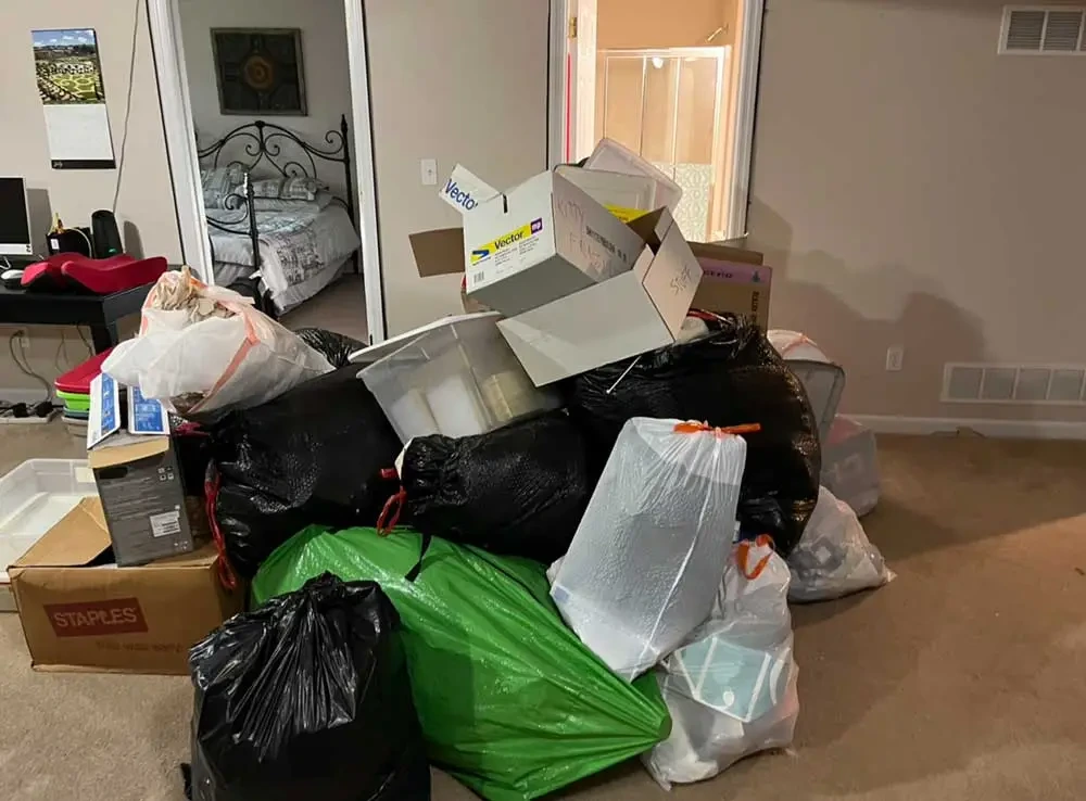 Bedroom filled with bagged trash and stacked boxes ready for a Spring Cleaning Company hoarding cleanout in St. Louis, Missouri